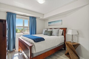 Second bedroom with a queen bed, blackout blinds & clothing storage.