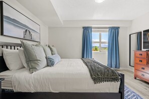 Primary bedroom with a king bed, smart TV, walk-through closet & private ensuite full bathroom.