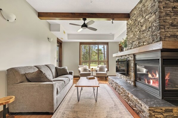 Living room with a gas fireplace, Smart TV with cable & cozy seating with a pull-out couch bed.