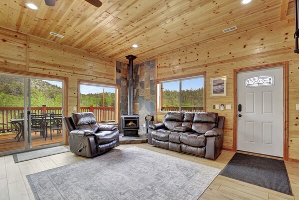 Spacious living room with comfortable seating and a cozy wood-burning fireplace.