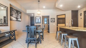 The unit has a dining table for four, and bar stools at the kitchen counter