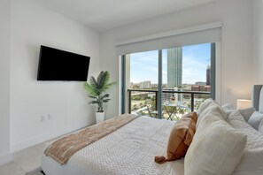 Bedroom  | Plush queen bed with access to private balcony, offers stunning city views.