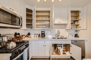 Enjoy the full kitchen and dining area with a refrigerator, freezer, oven, stove, microwave, dishwasher, coffee, creamers, mixers, spices, pots, pans, cooking supplies, cutlery, cups, plates, bowls, utensils, small appliances, and many more essentials.
