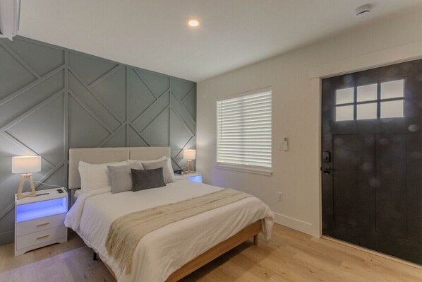Relax in comfort on this spacious queen-sized bed, surrounded by a beautiful accent wall that adds a touch of charm to the room. Crisp white linens create a serene atmosphere, making it the perfect spot to unwind after a day of exploring the local attract