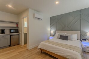 Relax in comfort on this spacious queen-sized bed, surrounded by a beautiful accent wall that adds a touch of charm to the room. Crisp white linens create a serene atmosphere, making it the perfect spot to unwind after a day of exploring the local attract