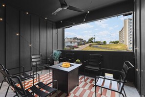 Top floor private patio with a gas firepit, string lights, and plenty of seating for your group to convene and enjoy some fresh air. Please note we do not supply the propane for the firepit.