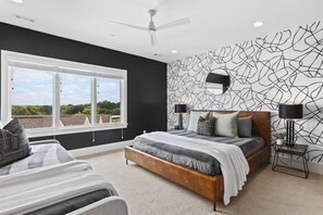 Bedroom #4 on the top floor with a King bed, Twin bed, Smart TV, full-length mirror, a dedicated workspace, large ensuite bathroom, and huge walk-in closet.