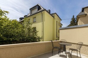 Enjoy your morning coffee or evening drinks on the private outdoor patio, surrounded by lush greenery and charming neighborhood views.