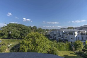 Stunning panoramic views from the balcony, overlooking lush greenery and modern architecture, ideal for unwinding and enjoying the scenery.