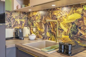 Close-up of the modern kitchen featuring vibrant backsplash, state-of-the-art sink, and convenient appliances, ideal for gourmet cooking