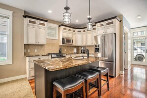 The Kitchen Features Stainless Steel Appliances, a Gas Range and a Bar Top Island