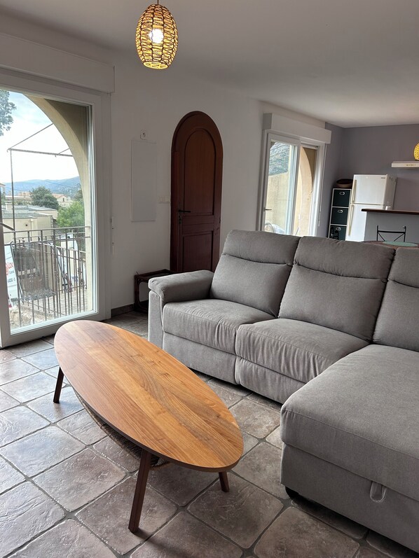 Salon avec baie vitrée donnant sur l’extérieur