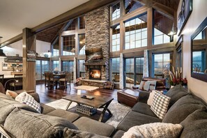 This stunning living room features towering windows and a cozy fireplace, creating the perfect blend of warmth and elegance.