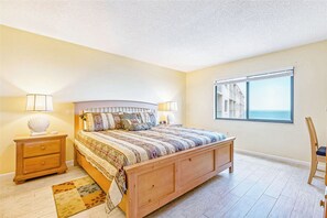 Wake up to the soothing sight of the ocean in this inviting master bedroom with king size bed