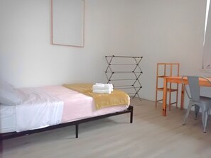 The guest bedroom features a full bed, a work station, and clothing storage.
