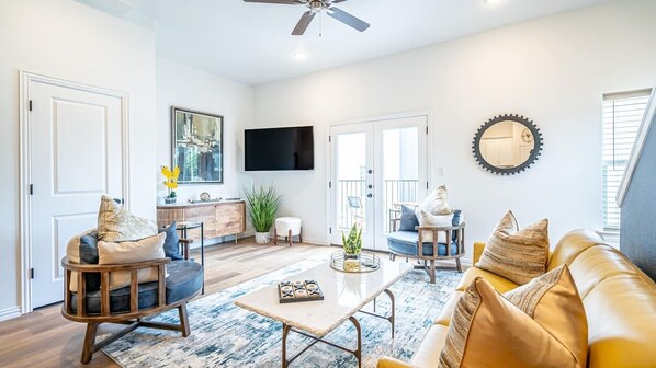 Enjoy a bright and comfortable living room with modern furnishings and cozy seating, the perfect place to unwind after exploring Arlington's entertainment district.