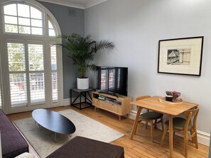 Television with Free Access to Local Channels and Netflix sitting atop a Credenza with an interesting selection of Books. The Lounge Area also features a Designer Coffee Table.