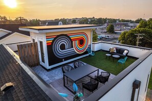 Private rooftop deck outdoor dining table (seats 4) and lounge area. Entire space is lined with bistro lights and includes a photo op mural!