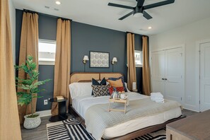 Primary bedroom with King bed, designer furnishings, smart TV, closet, and en-suite bathroom.