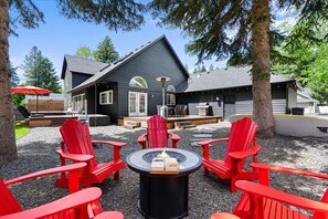 6 Adirondack chairs around a fire pit under pine trees. Propane provided!