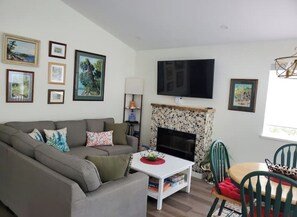 Living room with original artwork of area. Electric fireplace.