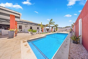 Dive into relaxation in our crystal-clear pool area of the home in Oranjestad, Aruba - Bask in the warm sun on our comfortable loungers, strategically placed by the poolside - Surrounded by lush greenery our pool area offers serene, private retreat