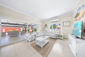 Enjoy the expansive space of the living area of the home in Oranjestad, Aruba - Sink into the plush seating, offering ultimate comfort and a cozy spot to unwind - Thoughtful accents and décor elements add character and warmth to the living space