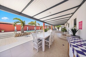 Enjoy charming al fresco dining in our outdoor dining area of the home in Oranjestad, Aruba - Spacious seating arrangement comfortably accommodates all guests for gatherings - The elegant table setup features stylish furniture and chic tableware