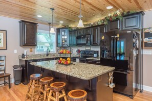 Full kitchen with kitchen island with seating for 4 and all basic amenities including a dishwasher and two types of coffee makers (Standard Drip & Keurig).