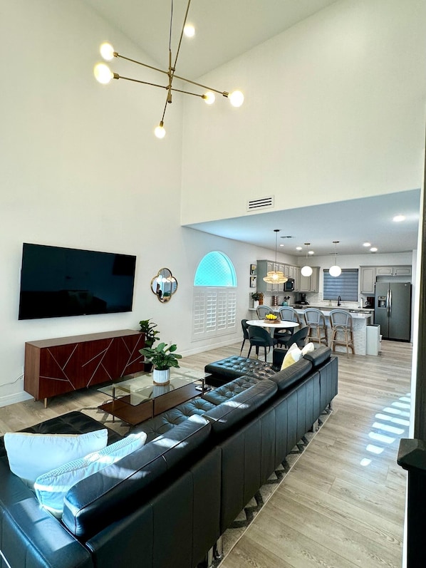 Living area with large sectional and 75 inch Smart TV.