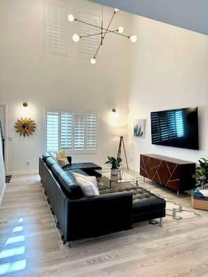 Living area with large sectional and 75 inch Smart TV.