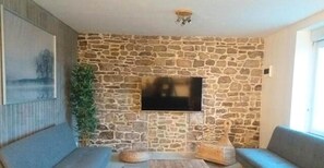 Large lounge on the ground floor of the Bâtisse with connected TV