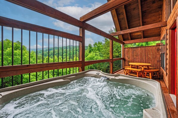 Enjoy serene views from our cabin's private hot tub and spacious back deck.