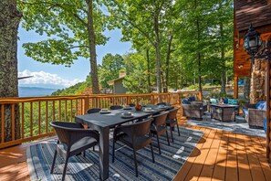 Wth a dining area nearby and two eggshell swings, all set against breathtaking mountain and tree views