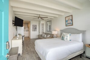 Cozy beach-themed studio with a comfy queen bed, sofa, and kitchenette.