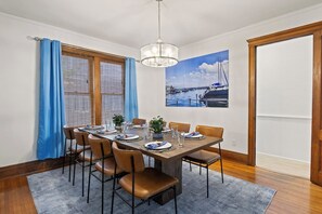 Dining Room -Elegant dining room with a large table, leather chairs, and marina artwork. Natural light from large windows.