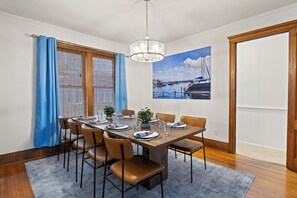 Dining Room -Elegant dining room with a large table, leather chairs, and marina artwork. Natural light from large windows.