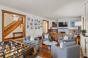 Living Room with Games - Modern living room featuring cozy seating, a foosball table, and an inviting fireplace, perfect for entertaining and relaxation.
