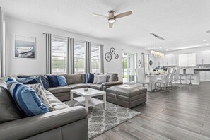 Main family lounge with windows overlooking the pool area