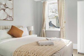 The primary bedroom, located upstairs, features a queen-size bed and an ensuite bathroom. 