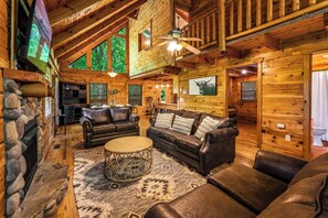 Spacious Living Room with Ample Seating: Featuring three comfortable couches, a cozy gas fireplace, and an open concept kitchen, living, and dining area, our cabin is perfect for relaxation and gathering with your loved ones.