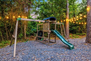 Playground Paradise: Slide into fun beneath twinkling lights in this enchanting outdoor play area!