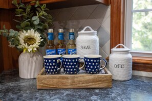 Coffee essentials in a delightful setup, including blue porcelain mugs and a fresh flower vase.