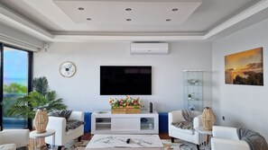 Azure Serenity Villa's living room is a modern oasis, featuring a large smart TV, AC, and ample natural light, ensuring a bright and comfortable stay in Gaula, Santa Cruz Madeira. #livingroom #decor #luxury