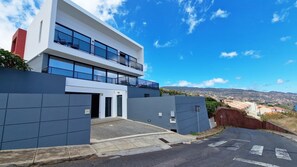 Azure Serenity Villa's facade showcases sleek, luxurious horizontal lines, reflecting modern design in the scenic Gaula, Santa Cruz Madeira. A stunning exterior that promises elegance and sophistication. #luxuryvilla