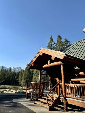 Discover rustic charm and stunning mountain views from the front porch of this custom-built log home, where the beauty of nature meets the comfort of home.