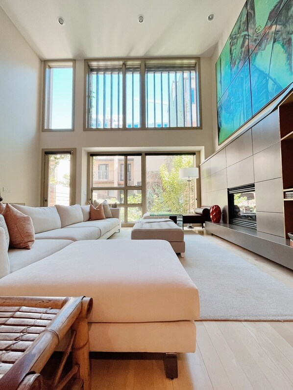 Soaring windows with stunning original art work, gas fireplace, smart tv.