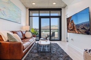 Beautifully designed living room. 65" TV, leather sofa and amazing views of mountains and city skyline.