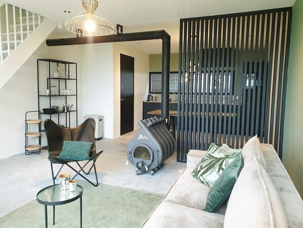Stylish comfort in a cowshed! Relax on the sofa, warm up by the stove, and enjoy the surprising mix of rural life and modern design—yes, the cows really are just next door.