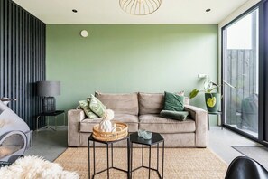 Sink into this plush sofa surrounded by soft greens, natural textures, and peaceful farm vibes. A comfy corner in the heart of a real cowshed, perfect for slow mornings or cozy evenings.